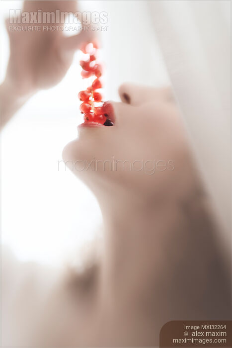 Closeup of a woman sensual mouth with open lips eating red currants Stock photo of Closeup of a woman sensual mouth with open lips eating red currants Buy commercial use license at MaximImages