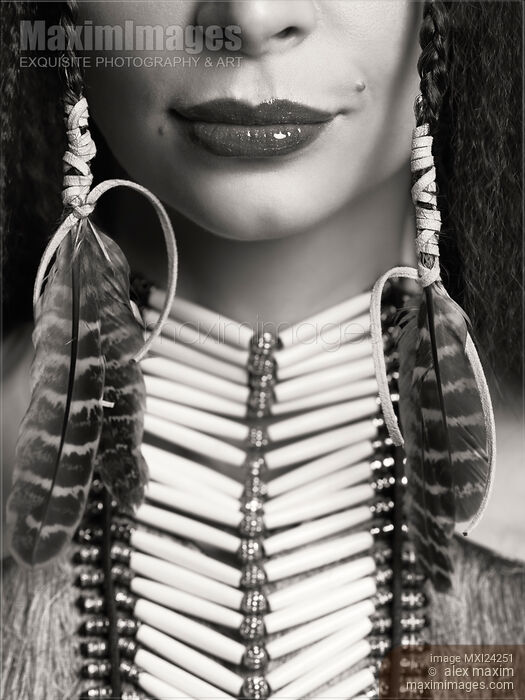 Stock photo of Closeup of lips of a woman wearing aboriginal necklace and feathers Buy commercial use license at MaximImages