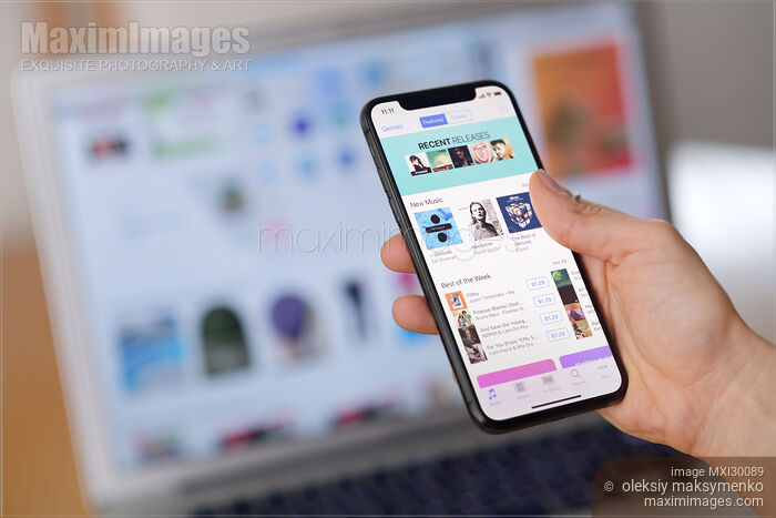 Closeup of woman hand with Apple iPhone X displaying iTunes store music on its screen Stock photo of Closeup of woman hand with Apple iPhone X displaying iTunes store music on its screen Buy commercial use license at MaximImages