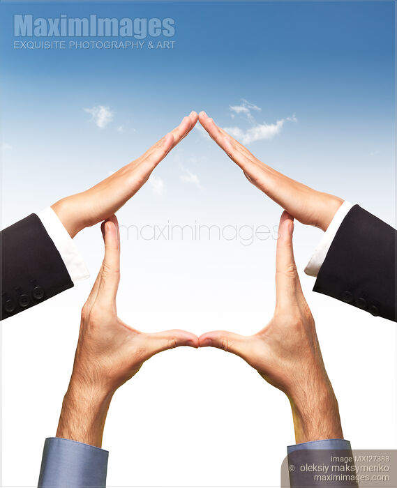 Stock photo of Conceptual home symbol made by hands over blue sky Buy commercial use license at MaximImages