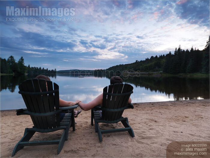 Stock photo of Couple Sitting in Chairs at the Lake Buy commercial use license at MaximImages