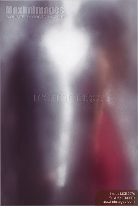 Stock photo of Couple standing facing each other behind hazy frosted glass with heart shaped light them Buy commercial use license at MaximImages