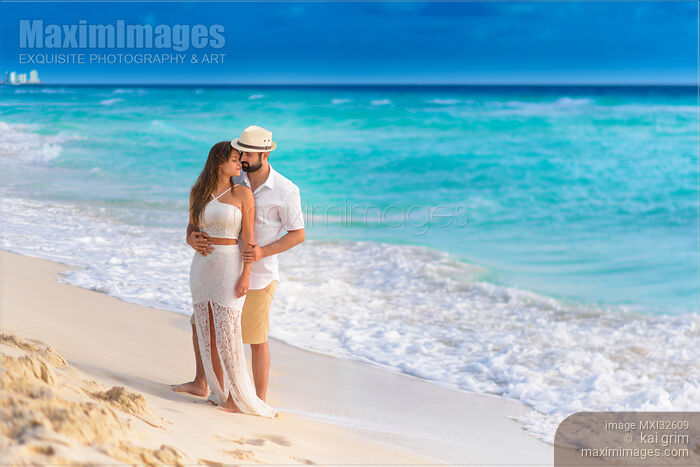 Stock photo of Couple together in an embrace on a sunny sandy sea shore of a Caribbean Sea beach in Cancun Mexico Buy commercial use license at MaximImages