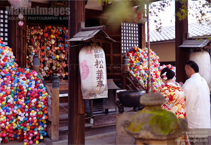 Stock photo of Couple wearing traditional kimonos praying at Yasaka Koshindo in Kyoto Japan Buy commercial use license at MaximImages