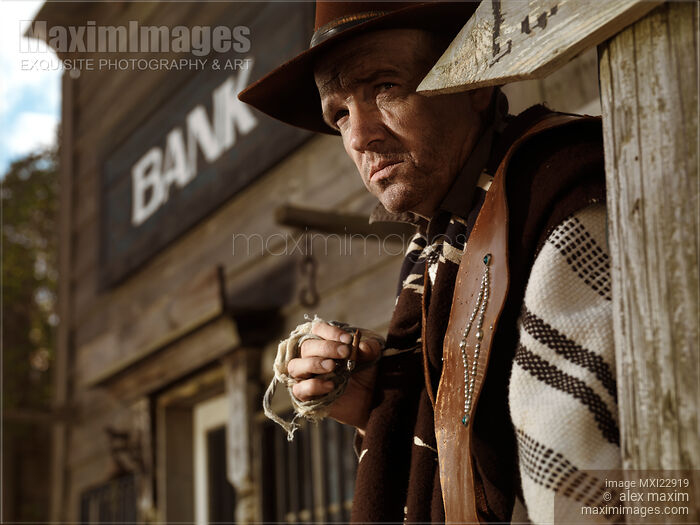 Stock photo of Cowboy Smoking a Cigar Outside of a Bank Building Buy commercial use license at MaximImages
