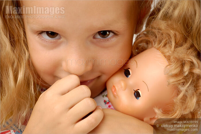 Stock photo of Cute Little Girl Holding a Doll Buy commercial use license at MaximImages