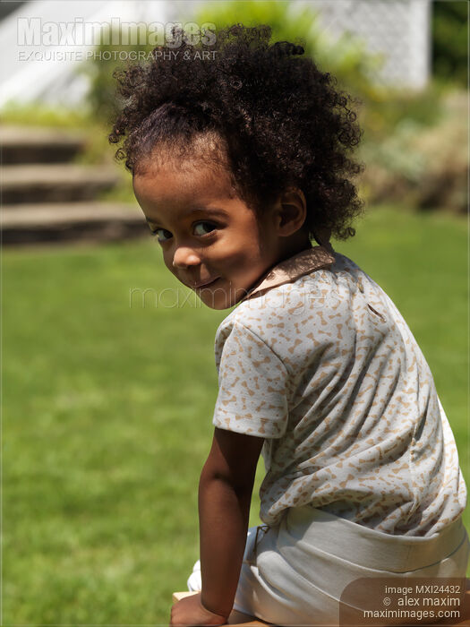 Stock photo of Cute smiling girl sitting in the backyard Buy commercial use license at MaximImages