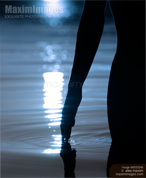 Dark silhouette of a woman hand touching glowing with moonlight sea water at night Stock photo of Dark silhouette of a woman hand touching glowing with moonlight sea water at night Buy commercial use license at MaximImages
