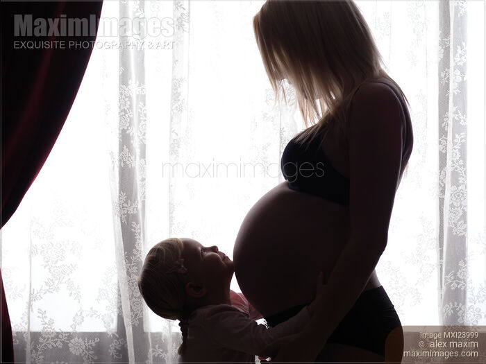 Daughter Hugging Her Pregnant Mother Around Belly Stock photo of Daughter Hugging Her Pregnant Mother Around Belly Buy commercial use license at MaximImages
