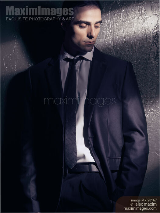 Dramatic portrait of man in black suit in dim light Stock photo of Dramatic portrait of man in black suit in dim light Buy commercial use license at MaximImages