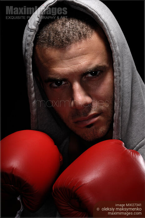 Dramatic portrait of man wearing boxing gloves Stock photo of Dramatic portrait of man wearing boxing gloves Buy commercial use license at MaximImages