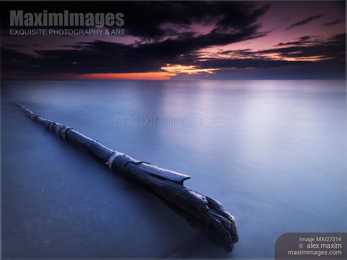 Stock photo of Driftwood in dramatic sunset scenery at lake Huron Grand Bend Buy commercial use license at MaximImages
