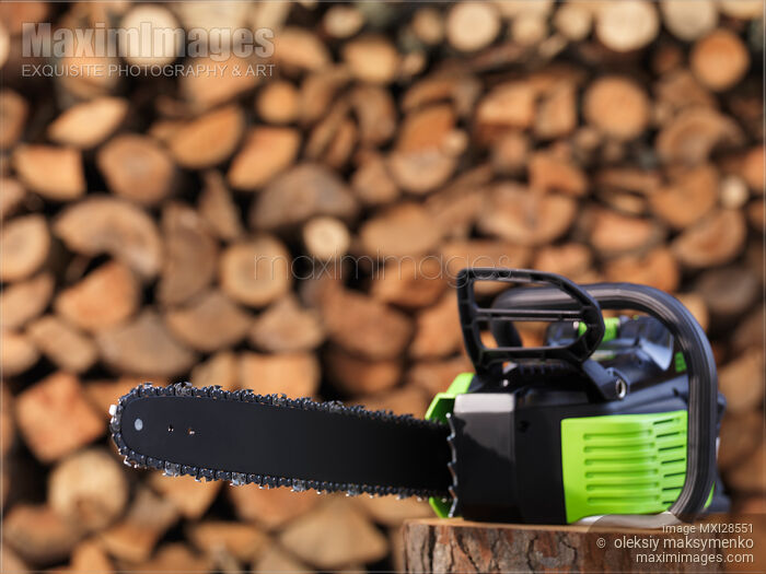 Electric Cordless Chainsaw by stacked firewood Stock photo of Electric Cordless Chainsaw by stacked firewood Buy commercial use license at MaximImages