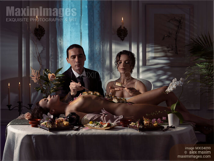 Elegant couple eating Nyotaimori sushi served on naked body of beautiful nude woman lying on restaurant table Stock photo of Elegant couple eating Nyotaimori sushi served on naked body of beautiful nude woman lying on restaurant table Buy commercial use license at MaximImages