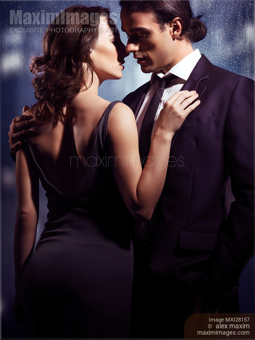 Elegant couple kissing in front of window Stock photo of Elegant couple kissing in front of window Buy commercial use license at MaximImages