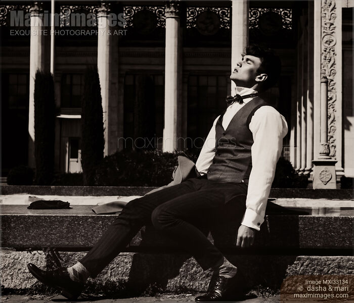 Elegantly dressed man sitting by a fountain taking a break enjoying the sunshine outdoors with abandon Stock photo of Elegantly dressed man sitting by a fountain taking a break enjoying the sunshine outdoors with abandon Buy commercial use license at MaximImages