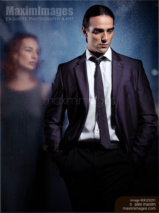 Emotional portrait of a couple separated with glass Stock photo of Emotional portrait of a couple separated with glass Buy commercial use license at MaximImages