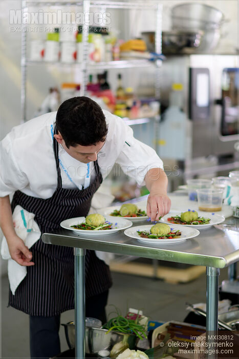 Executive Chef Quang Dang garnishing a gourmet competition meal at BC Seafood Festival Stock photo of Executive Chef Quang Dang garnishing a gourmet competition meal at BC Seafood Festival Buy commercial use license at MaximImages