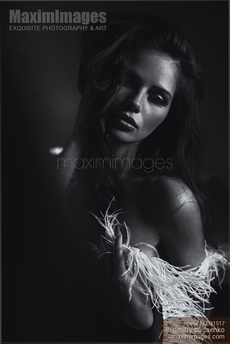 Stock photo of Expressive black and white portrait of a beautiful woman with feather boa around shoulders Buy commercial use license at MaximImages