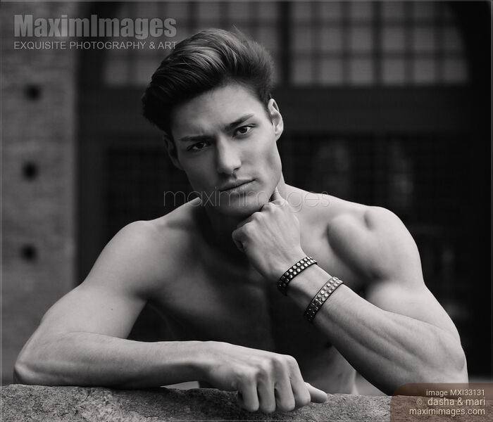 Expressive black and white portrait of a sexy handsome muscular man with a bare torso and stylish short hair