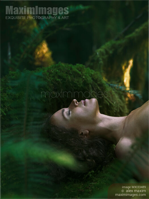 Stock photo of Face of a woman lying on green moss forest bathing, Shinrin-Yoku concept Buy commercial use license at MaximImages