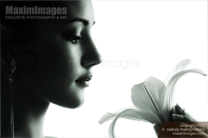 Face of young woman holding lily Stock photo of Face of young woman holding lily Buy commercial use license at MaximImages