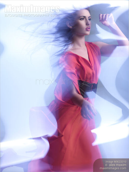 Fashion Photo of a Woman in Shining Blue Light Wearing a Red Dress Stock photo of Fashion Photo of a Woman in Shining Blue Light Wearing a Red Dress Buy commercial use license at MaximImages
