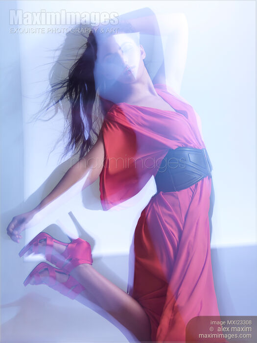 Stock photo of Fashion Photo of Woman in Red Dress Jumping in Blue Light Buy commercial use license at MaximImages