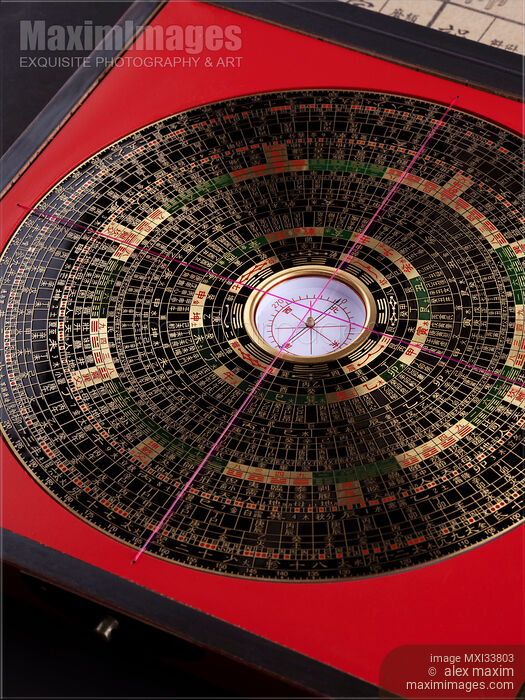 Stock photo of Feng Shui geomantic compass Luo Pan black metal plate of the Heaven dial with symbols in red Earth plate Buy commercial use license at MaximImages