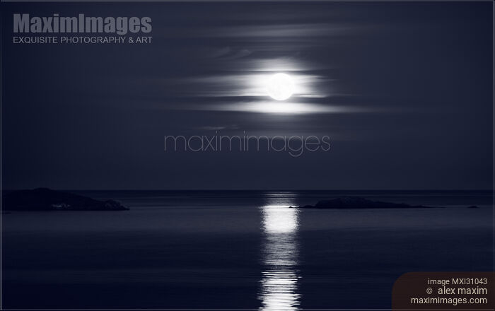 Stock photo of Full Harvest Moon rising above Pacific ocean in autumn Black and white Buy commercial use license at MaximImages