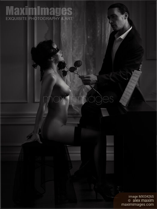 Stock photo of Gentleman caressing with a rose a gorgeous woman sitting at a piano naked and blindfolded. Black and white. Buy commercial use license at MaximImages