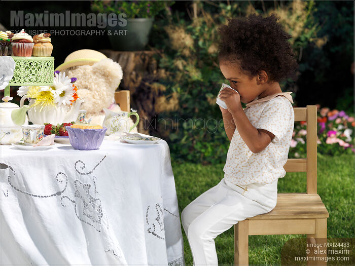 Stock photo of Girl drinking tea at a party table Buy commercial use license at MaximImages