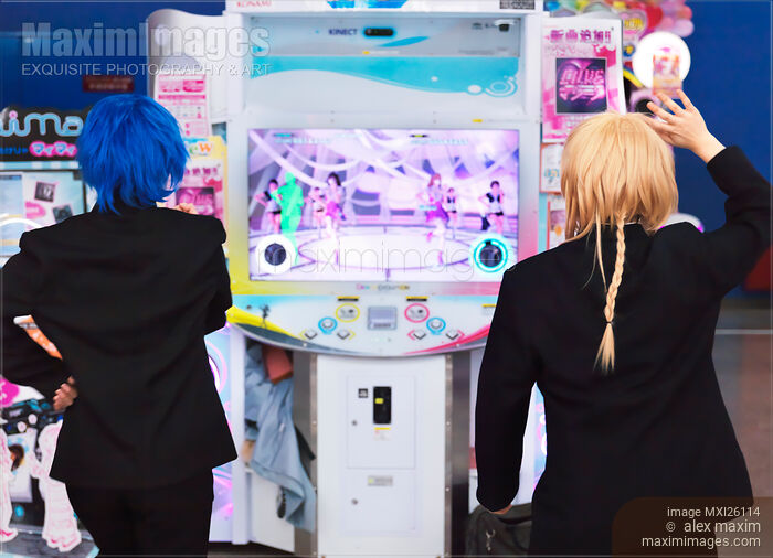 Stock photo of Girls playing dance station slot machine at arcade Buy commercial use license at MaximImages