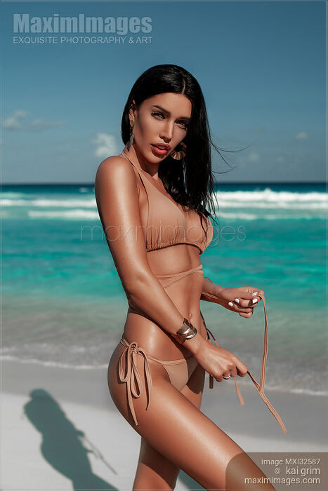 Glamorous sexy sun-tanned exotic woman in a bikini swimsuit posing on a sandy shore of Caribbean Sea beach Stock photo of Glamorous sexy sun-tanned exotic woman in a bikini swimsuit posing on a sandy shore of Caribbean Sea beach Buy commercial use license at MaximImages