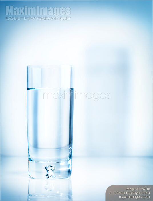 Stock photo of Glass of water on light blue background Buy commercial use license at MaximImages