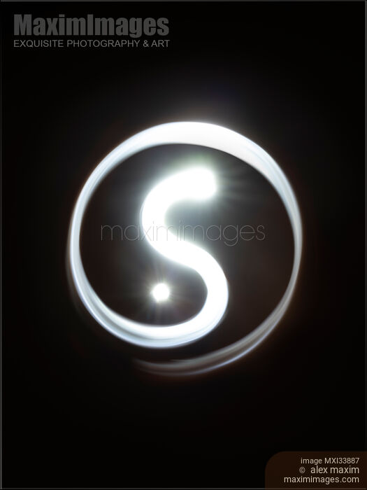 Stock photo of Glowing snake or dragon like ancient Yin-Yang symbol on black background Buy commercial use license at MaximImages