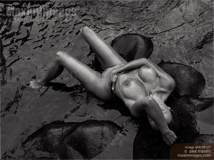Gorgeous nude woman lying in dark sea water. Black and white erotic photograph view from above. Stock photo of Gorgeous nude woman lying in dark sea water. Black and white erotic photograph view from above. Buy commercial use license at MaximImages