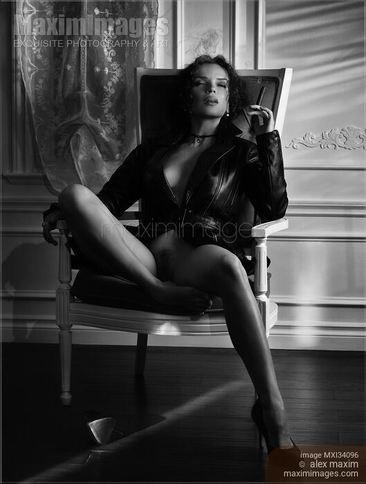 Gorgeous seductive woman in leather jacket sitting half naked in vintage chair smoking a cigar. Black and white. noir. Stock photo of Gorgeous seductive woman in leather jacket sitting half naked in vintage chair smoking a cigar. Black and white. noir. Buy commercial use license at MaximImages