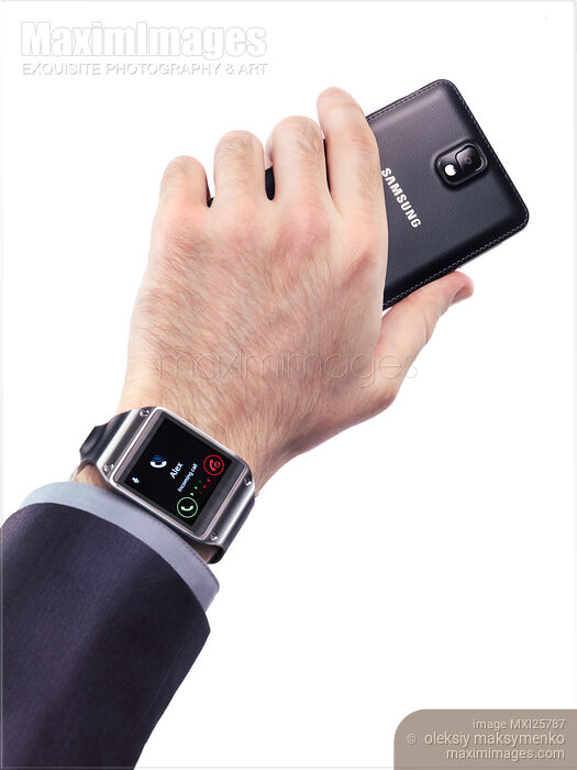 Stock photo of Hand with Samsung smartphone and Galaxy Gear watch Buy commercial use license at MaximImages