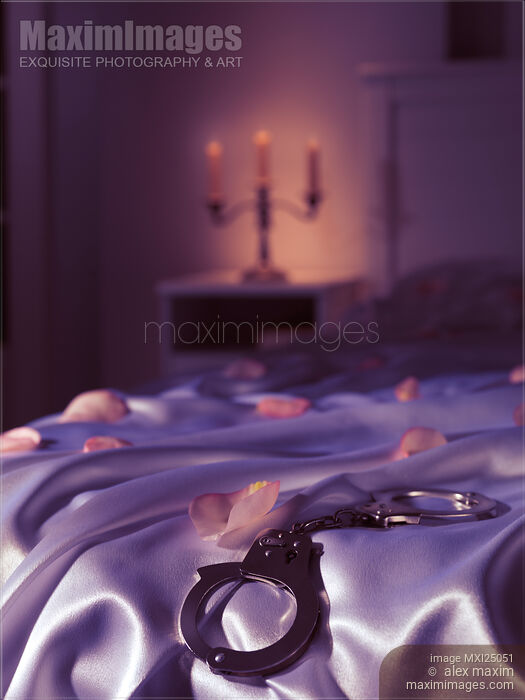 Handcuffs and rose petals on bed Stock photo of Handcuffs and rose petals on bed Buy commercial use license at MaximImages
