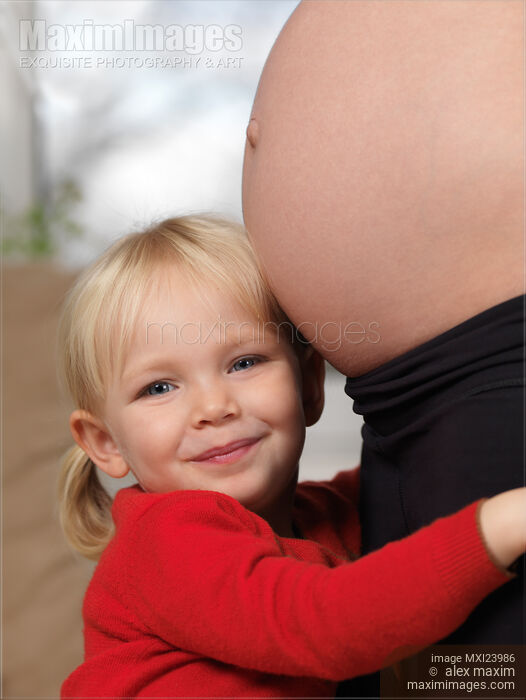 Stock photo of Happy Daughter Hugging Her Pregnant Mother Across Belly Buy commercial use license at MaximImages