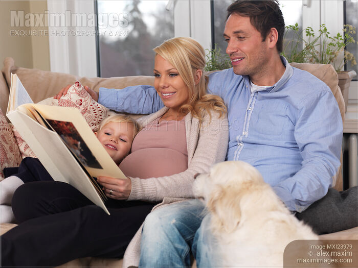 Happy Family with Pregnant Mother Watching Photo Album Stock photo of Happy Family with Pregnant Mother Watching Photo Album Buy commercial use license at MaximImages