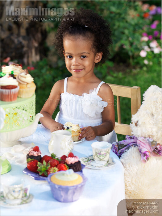 Photo of Happy young girl eating a cupcake at a party Stock Image MXI24427