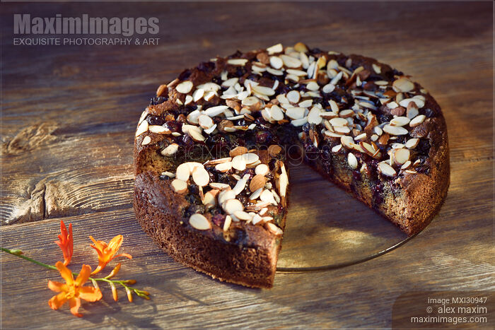 Healthy home-made Banana bread with berries and almonds on a table artistic food still life Stock photo of Healthy home-made Banana bread with berries and almonds on a table artistic food still life Buy commercial use license at MaximImages