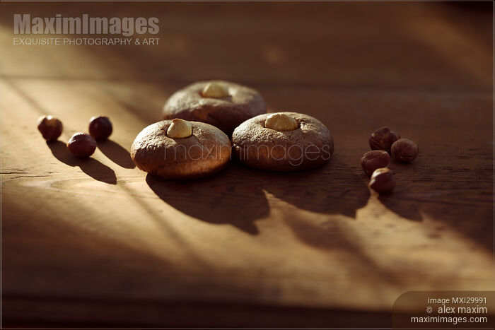Stock photo of Healthy home-made Hazelnut butter cookies with hazelnuts on rustic table in dramatic sunlight Buy commercial use license at MaximImages