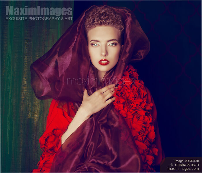 High fashion portrait of a red-haired woman wearing a purple shawl around her face and red lace dress Stock photo of High fashion portrait of a red-haired woman wearing a purple shawl around her face and red lace dress Buy commercial use license at MaximImages