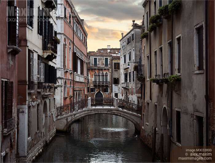 Stock photo of Historic old buildings and a foot bridge over a waterway at sunset in Venice Italy Buy commercial use license at MaximImages