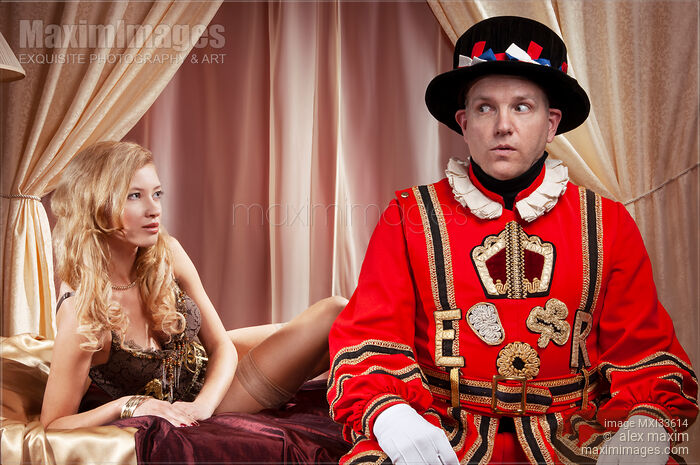 Humorous couple portrait of a Beefeater, Royal bodyguard and a beautiful sexy lady sitting on a bed Stock photo of Humorous couple portrait of a Beefeater, Royal bodyguard and a beautiful sexy lady sitting on a bed Buy commercial use license at MaximImages