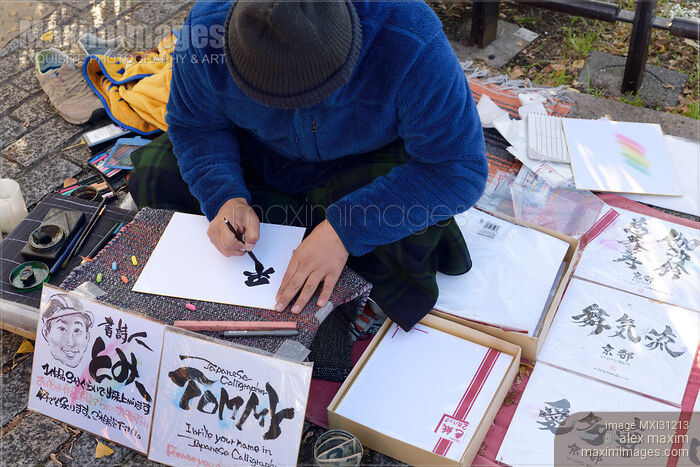 Stock photo of Japanese street artist calligrapher writing a name in Kanji characters Buy commercial use license at MaximImages