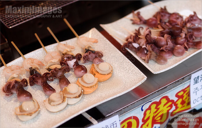 Stock photo of Japanese street food grilled seafood skewers with scallop and baby octopus Buy commercial use license at MaximImages